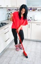 Attractive woman cleaning broken glass in kitchen Royalty Free Stock Photo