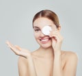 Attractive woman cleaning her face with a cotton pad