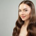 Attractive woman with clear skin and healthy curly brown hair smiling. Beautiful face close up. Skin care and hair care concept Royalty Free Stock Photo