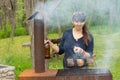 Attractive woman cooking over a picnic BBQ