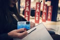 Attractive woman with credit card and shopping bag at red sale signs background. Lady doing shopping during total