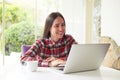 Attractive woman with cup of coffee and laptop near the window Royalty Free Stock Photo