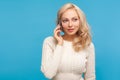 Attractive woman with curly blond hair talking cell phone, communication, suitable tariffs of mobile operators Royalty Free Stock Photo