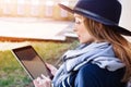 Attractive woman with digital tablet in hand talking on mobile phone with bpyfriend before a meeting with it. Young girl Royalty Free Stock Photo