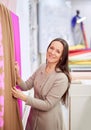 Female smiling designer choosing brown and pink fabrics