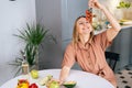 Attractive woman eating cherry tomatoes in modern kitchen. Royalty Free Stock Photo