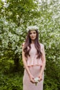 Attractive woman fashion model in flowers wreath in spring park outdoors. Beautiful girl outdoor portrait. Royalty Free Stock Photo