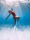 Attractive woman freediver with white fins posing underwater in sea