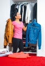 Attractive woman in front of closet full of clothes Royalty Free Stock Photo