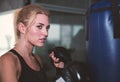 An attractive woman guarding and punching on a sand bag