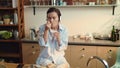 Woman eating yogurt in kitchen. Beautiful girl listening music in headphones. Royalty Free Stock Photo