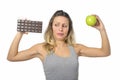 Attractive woman holding apple and chocolate bar in healthy fruit versus sweet junk food temptation Royalty Free Stock Photo