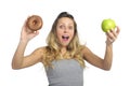 Attractive woman holding apple and chocolate donut in healthy fruit versus sweet junk food temptation Royalty Free Stock Photo