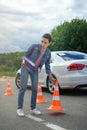 attractive woman holding car insurance and putting traffic cones