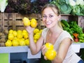 Attractive woman holding lemons in hands in fruit store Royalty Free Stock Photo