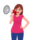 Attractive woman holding a megaphone/loud speaker and holding hand on hip. Girl making announcement with megaphone. Royalty Free Stock Photo