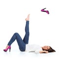 Attractive woman with jeans throwing a fuchsia heel