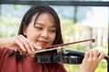 An attractive woman learning musician plays the violin at home. Composer creating songs with string instruments. Dreamy violinist