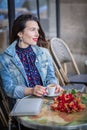 Attractive woman with long brunette hair sitting in the street cafe Royalty Free Stock Photo