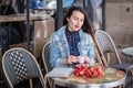 Attractive woman with long brunette hair sitting in the street cafe and drinking coffee Royalty Free Stock Photo