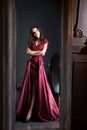 Attractive woman in long claret lace dress. Reflected in mirror