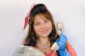 attractive woman with long hair in pink headband, blue gloves in retro pin-up style, pin-up look speaks on dial telephone, handset Royalty Free Stock Photo