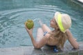 Attractive woman with long hair in a swimwear in the pool with cocktail in coconut Royalty Free Stock Photo