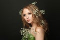 Attractive woman with long healthy curly hair, clear skin and white flowers on black background Royalty Free Stock Photo