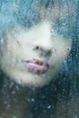 Attractive woman looking out of the window on rainy day Royalty Free Stock Photo