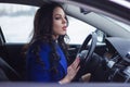 Attractive woman looks pensively into the windshield of the car