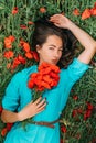 Attractive woman lying on poppy meadow.