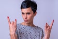 Attractive woman making a devil horns gesture Royalty Free Stock Photo