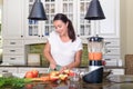 Attractive woman making smoothie in blender in modern kitchen Royalty Free Stock Photo