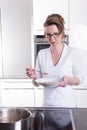 Attractive woman in modern ktchen cooking and eating soup