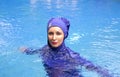 Attractive woman in a Muslim swimwear burkini in the pool Royalty Free Stock Photo