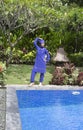 Attractive woman in a Muslim swimwear burkini stand on a pool side in a tropical garden Royalty Free Stock Photo