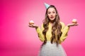attractive woman with party hat holding cupcakes