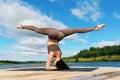 Attractive woman performing Shirsasana exercise with Hanumanasana, inverted asana, headstand with longitudinal splits