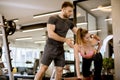 Attractive woman and a personal trainer with weight training at gym Royalty Free Stock Photo