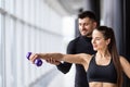 Attractive woman and a personal trainer with weight training at gym Royalty Free Stock Photo