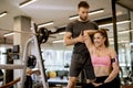 Attractive woman and a personal trainer with weight training at gym Royalty Free Stock Photo