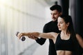 Attractive woman and a personal trainer with weight training at gym Royalty Free Stock Photo