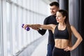 Attractive woman and a personal trainer with weight training at gym Royalty Free Stock Photo