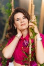 an attractive woman in a pink blouse with peonies on the swing.