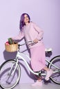attractive woman in pink clothing on bicycle with pineapple and bananas