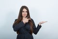 Attractive woman pointing fingers aside, looking at camera. Royalty Free Stock Photo