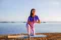 Attractive woman practicing Vatyasana, variation of Vrikshasana, Tree Pose. Outdoor yoga practice. Bali, Indonesea