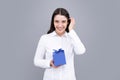 Attractive woman with present box posing with surprised face expression on gray background. Girl holding gift decorated Royalty Free Stock Photo