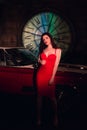 Attractive woman in red dress standing near retro red car Royalty Free Stock Photo