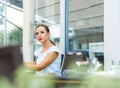 Attractive woman with red lips reads a newspaper sitting in a ca